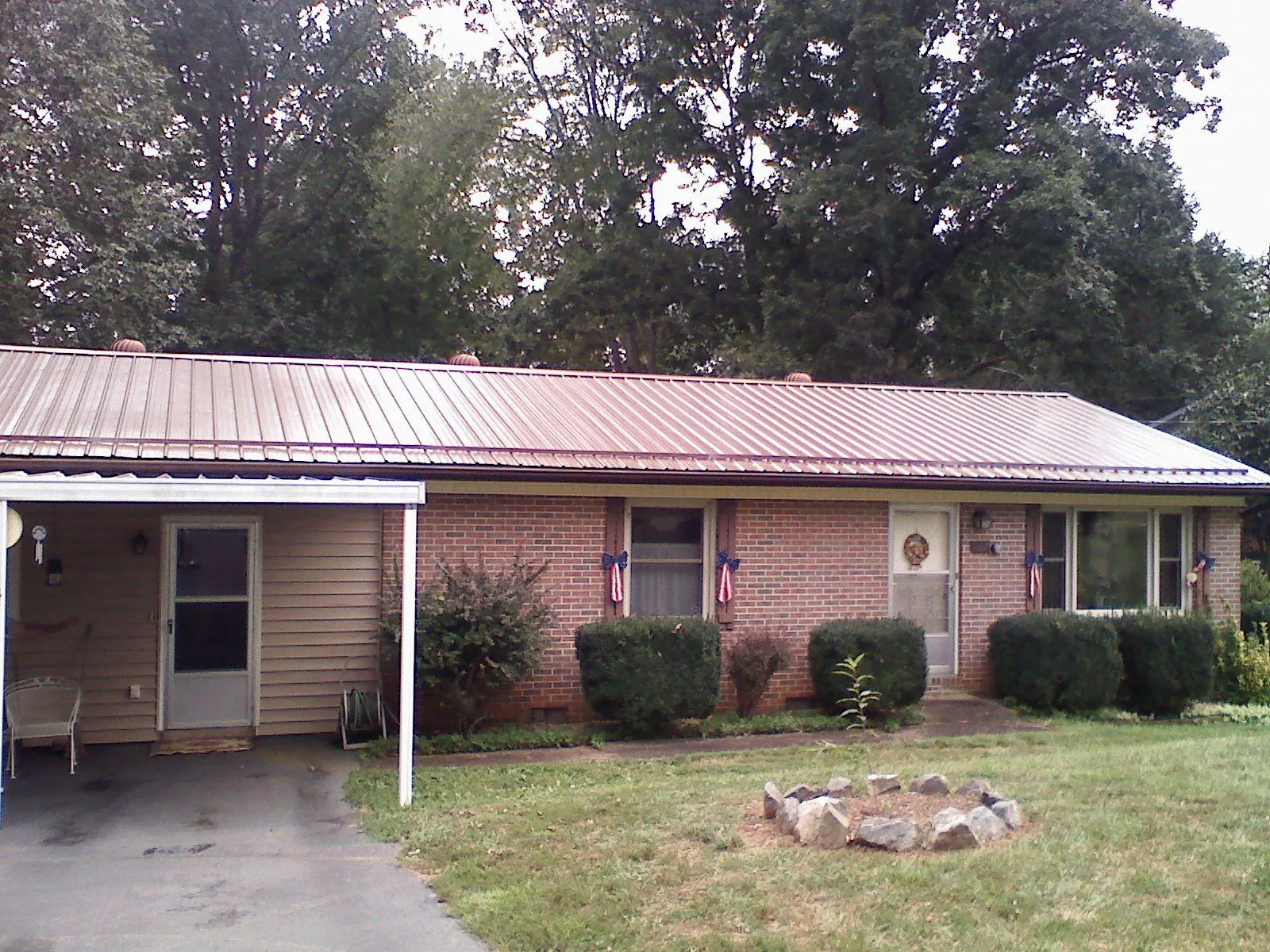 Bronze metal roof and carport on a brick ranch home — Roof Repair work by our crew in Cut Off