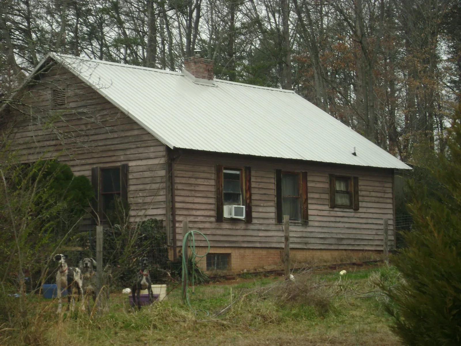 White metal roof on an old wood sided farmhouse, from a Metal Roof Installation job in Cut Off